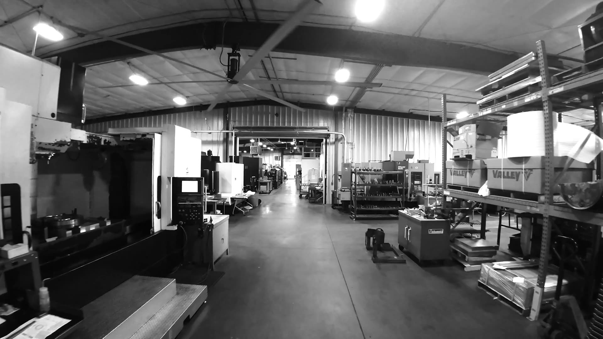A main aisle of the Midwest Machine and Tool shop floor, machining centers and racking running to the far wall